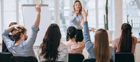 Increase. Female speaker giving presentation in hall at university workshop. Audience or conference hall. Rear view of unrecognized participants. Scientific, business event, training. Education